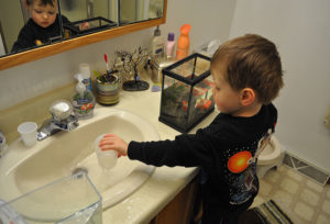 Ethan manually removing 50% of his aquarium water.
