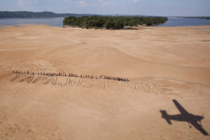 Greenpeace activists and Munduruku Indians use stones to form the Tapajós Free phrase on a sandy beach on the banks of the eponymous river, near the city of Itaituba, in Pará. The protest, which was attended by about 60 Mundurukú, It occurred in the region where the government plans to build the first of a series of five dams in the Tapajós basin. (Photo Greenpeace / Marizilda Cruppe 11/26/2014) - CC BY 2.0 via Fllckr