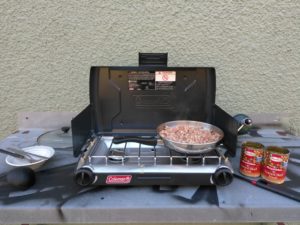 Cooking over a propane camp stove. It'll get the job done, but the novelty wears off after a while.