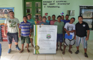 Trainers and fish collectors stand in a classroom in Santa Isabel after completing the Best Handling Practices training