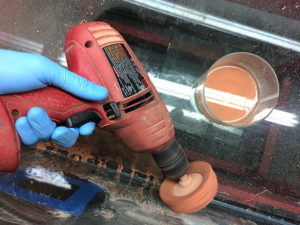 Polishing an aquarium glass panel with cerium oxide powder and a cloth buffing wheel in electric drill chuck.